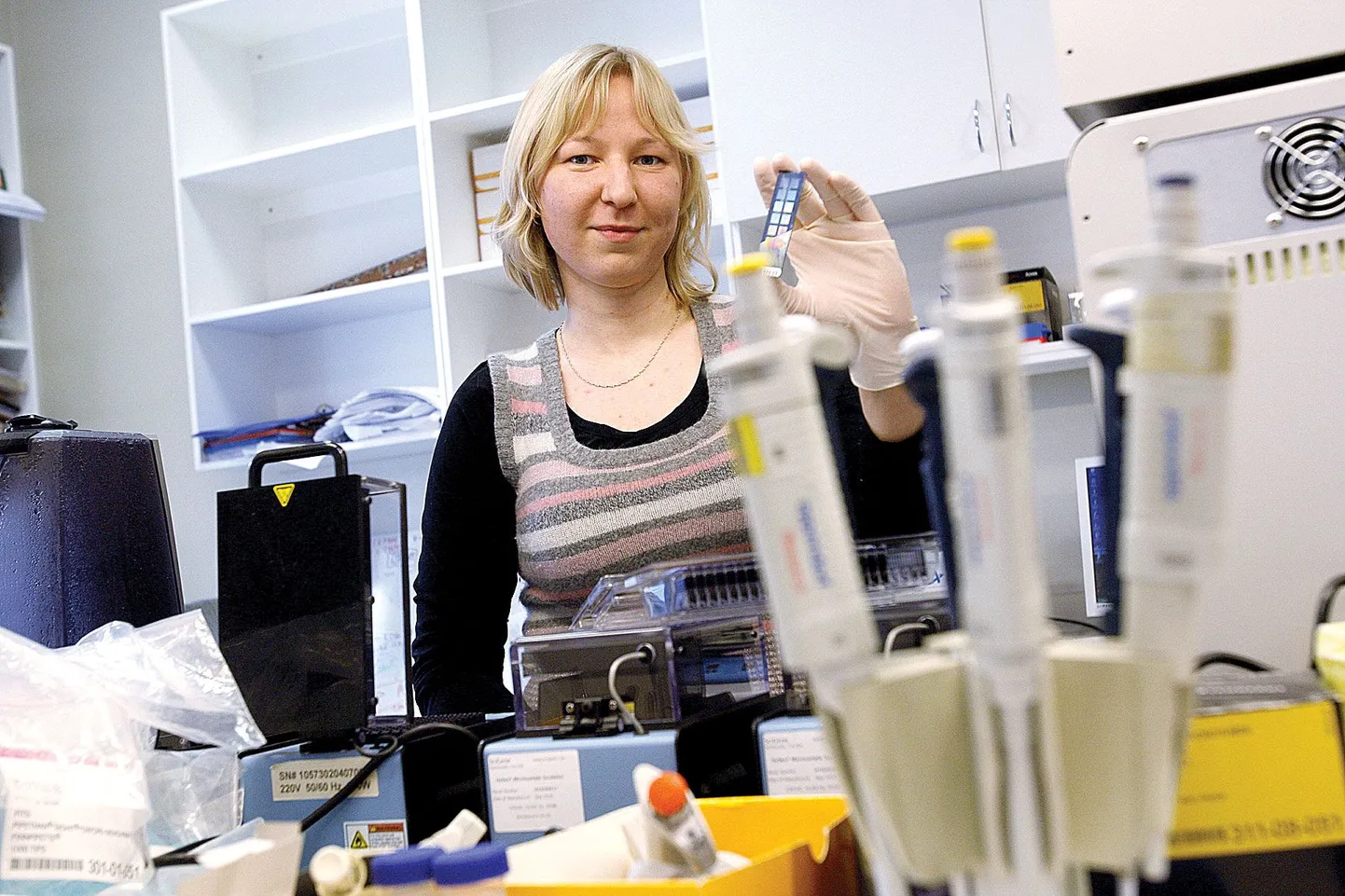 Reedel Tartu Ülikooli juures doktoritööd kaitsnud Inimpopulatsiooni geneetiku Mari Nelise käes on geenikiip, väike värviliselt läikiv klaasriba, mille peal on mitmesaja inimese geneetiline informatsioon.