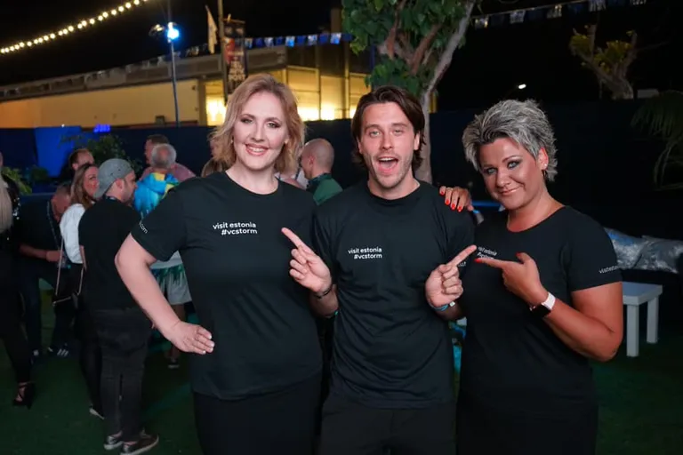 Külastage Eestit, visit Estonia! Eesti tiim Eurovisioonil annab oma riigi tutvustamiseks kõik. Taustajõud Kaire Vilgats ja Dagmar Oja, keskel Victor Crone. Tulihinhelised Eesti fännid astusid mitmetuhandepealise publiku ette visitestonia särkides.
