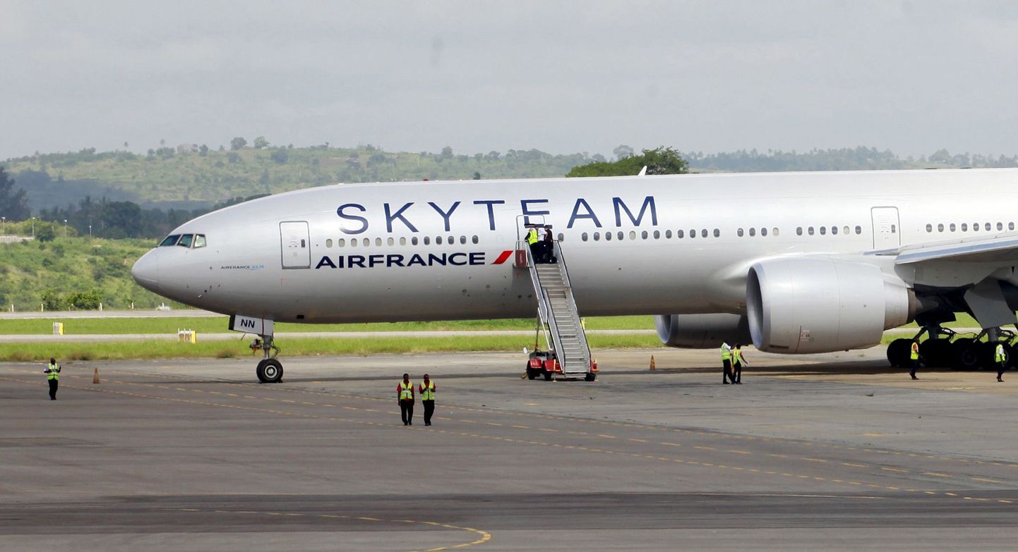 Airport workers are seen near the Air France Boeing 777 aircraft that made an emergency landing is pictured at Moi International Airport in Kenya's coastal city of Mombasa, December 20, 2015. The Air France flight from Mauritius diverted and made an emergency landing at Kenya's port city of Mombasa after a suspicious device was found in a toilet, Kenya's head of police and the airline said on Sunday. REUTERS/Joseph Okanga