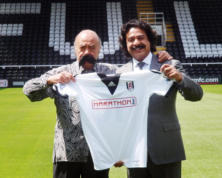2013. aastal ostis Shahid Khan (paremal, päris vuntsidega) Mohamed Al-Fayedilt (vasakul, valevuntsidega) toona kõrgliigas mänginud Fulhami jalgpalliklubi.