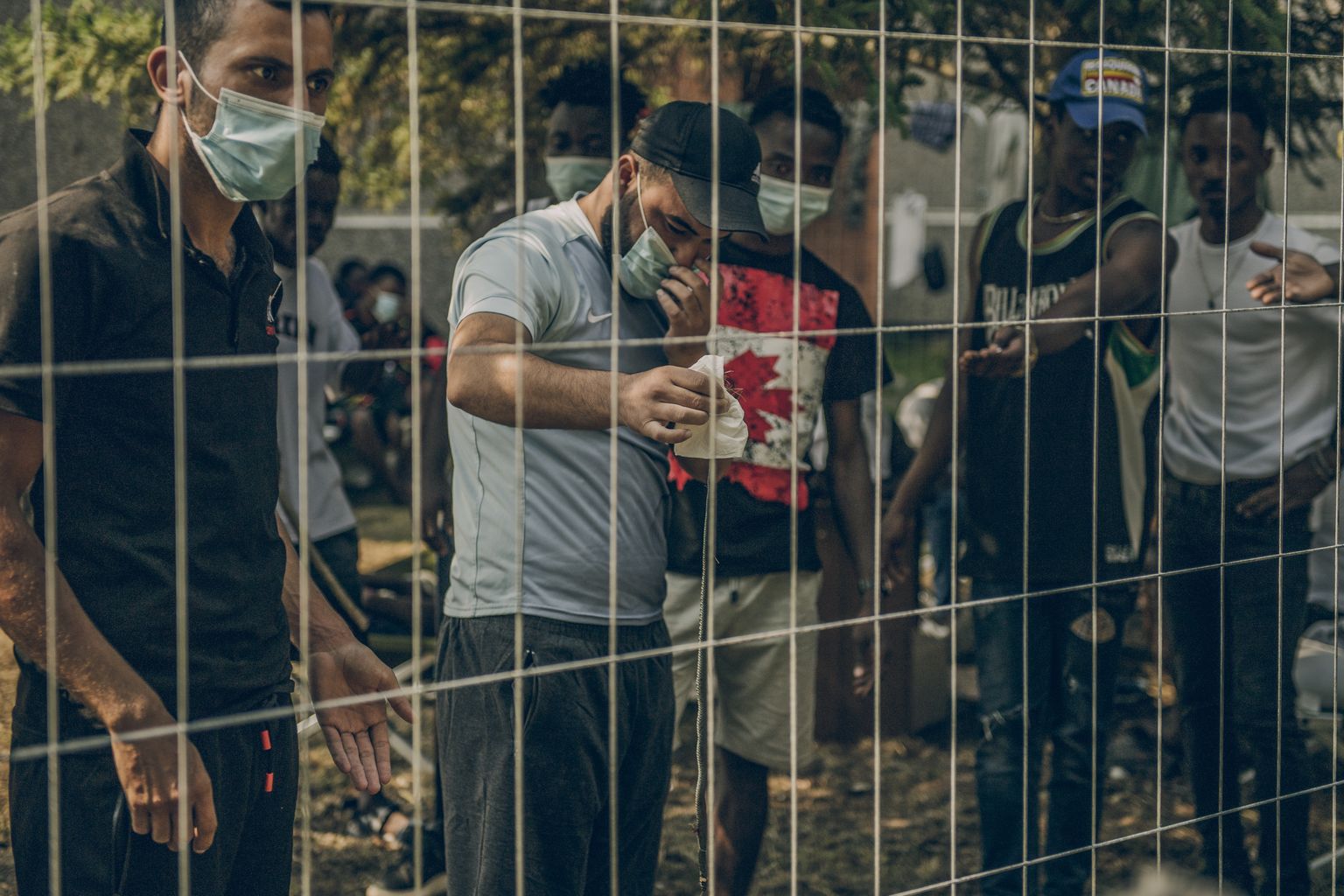 Мигранты показывают пойманную змею. Иллюстративное фото