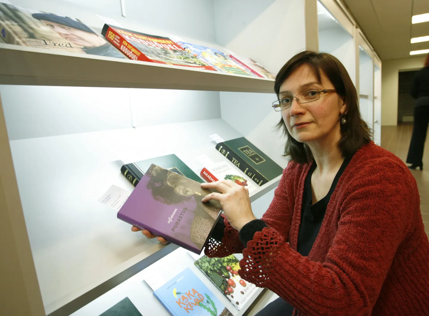 Eesti Kirjastuste Liidu tegevjuht Kaidi Urmet seab rahvusraamatukogu trepigaleriis üles näitust kirjastuste liidu möödunud aasta menuraamatutest. Urmeti käes on võiduraamat, Sofi Oksaneni «Puhastus».