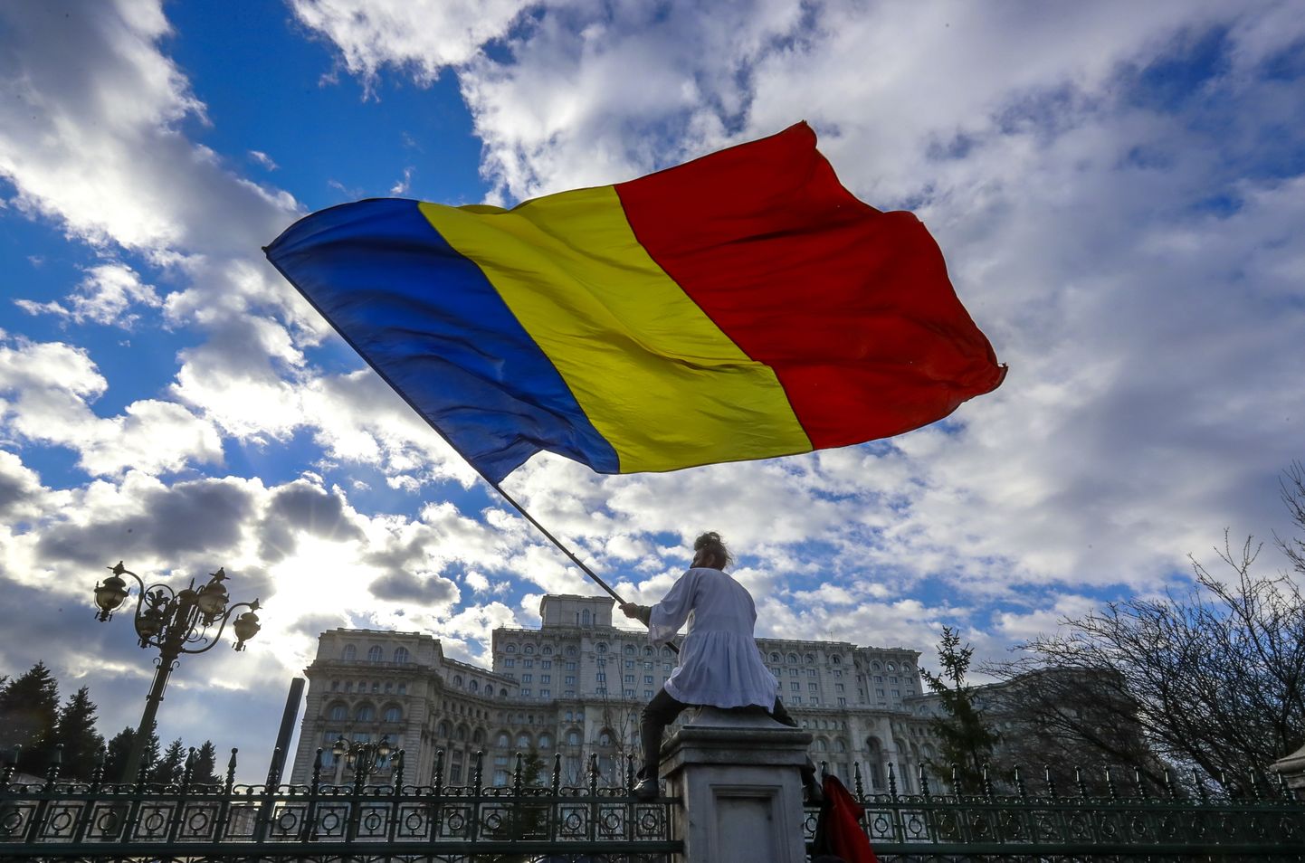 Meeleavaldaja lehvitamas Rumeenia lippu parlamendihoone ees Bukarestis.