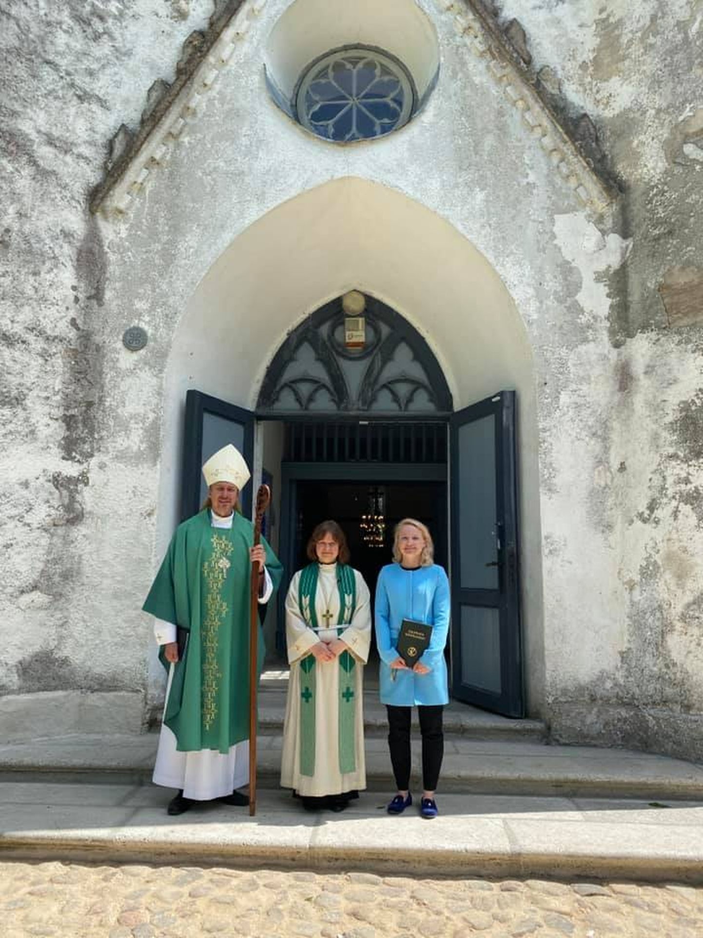 EELK peapiiskop Urmas Viilma koos õpetaja Katrin-Helena Melderi ja koguduse noortejuhi Tene Metsmaga kiriku ees.