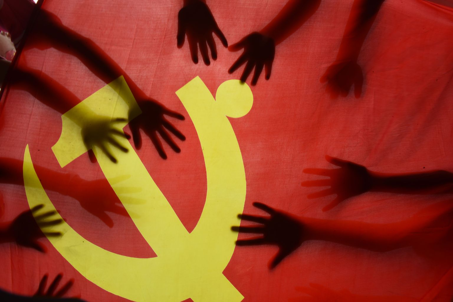 Laste käed Hiina Kommunistliku Partei lipu peal.