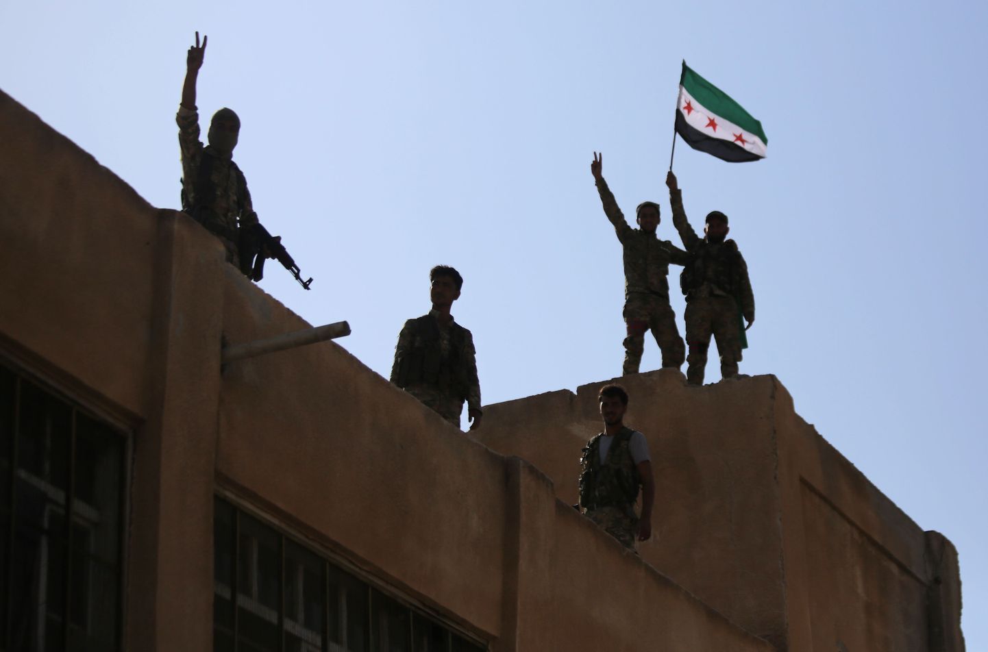Türgi toetatud Süüria võitlejad lehvitamas täna Tal Abyadi linnas Süüria opositsiooni lippu.