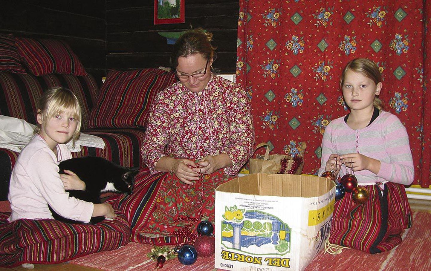 Uiõ-Matu talu elutoas sätivad pere nooremad lapsed Anni ja Maria ema Mare Mätasega jõulumänniehteid korda.