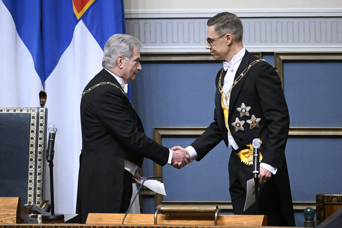 Уходящий президент Финляндии Саули Ниинистё пожимает руку новому президенту Александру Стуббу.