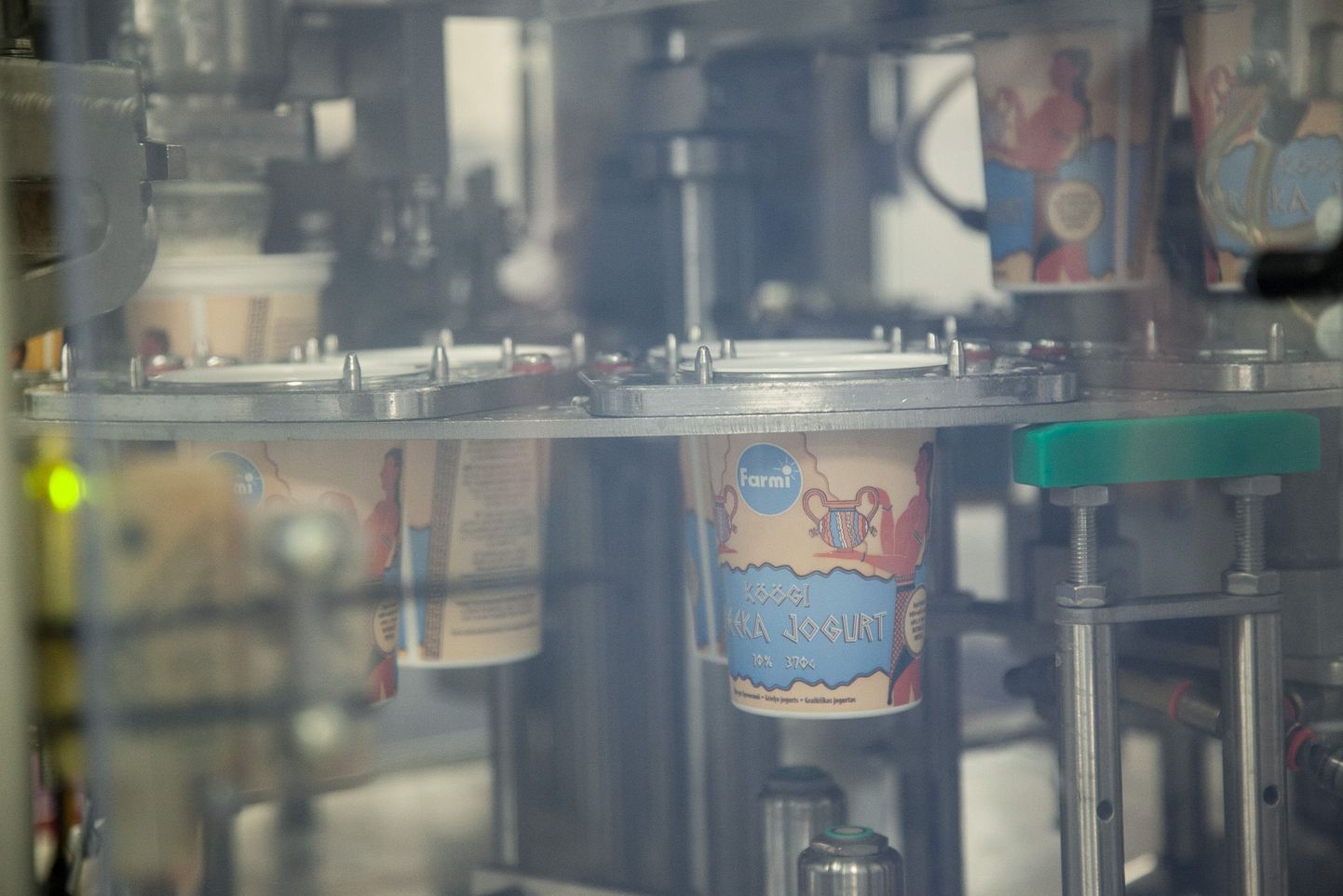 Стаканчики с йогуртом плывут за полупрозрачным окошком: технология велит прикрывать готовящийся напиток от света.