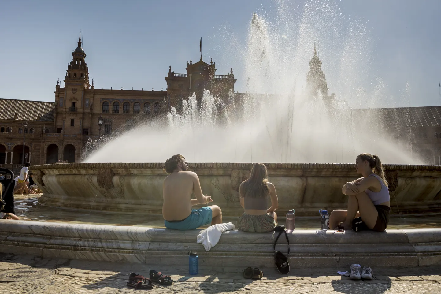 Sevilla turistid Plaza de España väljaku purskkaevu juures enda jahutamas.