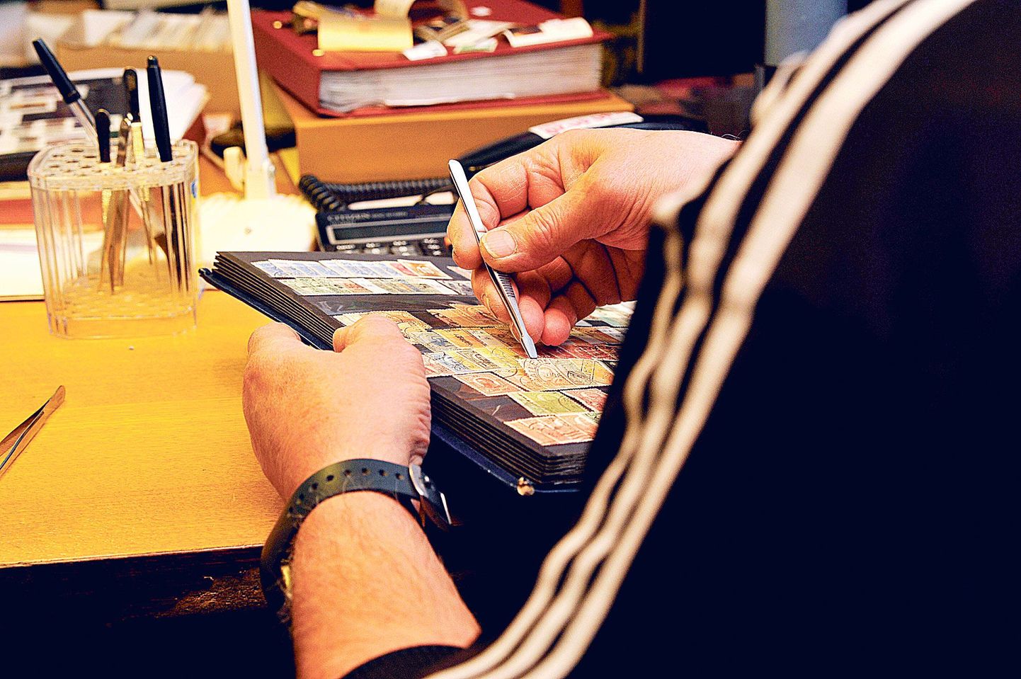 Margikoguja Sergei Valiulin sirvib olümpiamarke, albumist välja tõstab ta neid pintsettidega, on mugavam ja säästab marke.