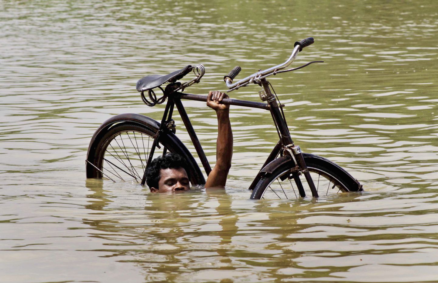 Üleujutusega võitlev külaelanik oma jalgrattaga Orissa osariigis Indias.