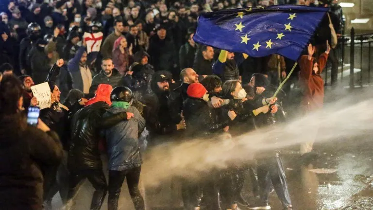 Протестующие с флагом С во время разгона акции 7 марта, 2023 года.