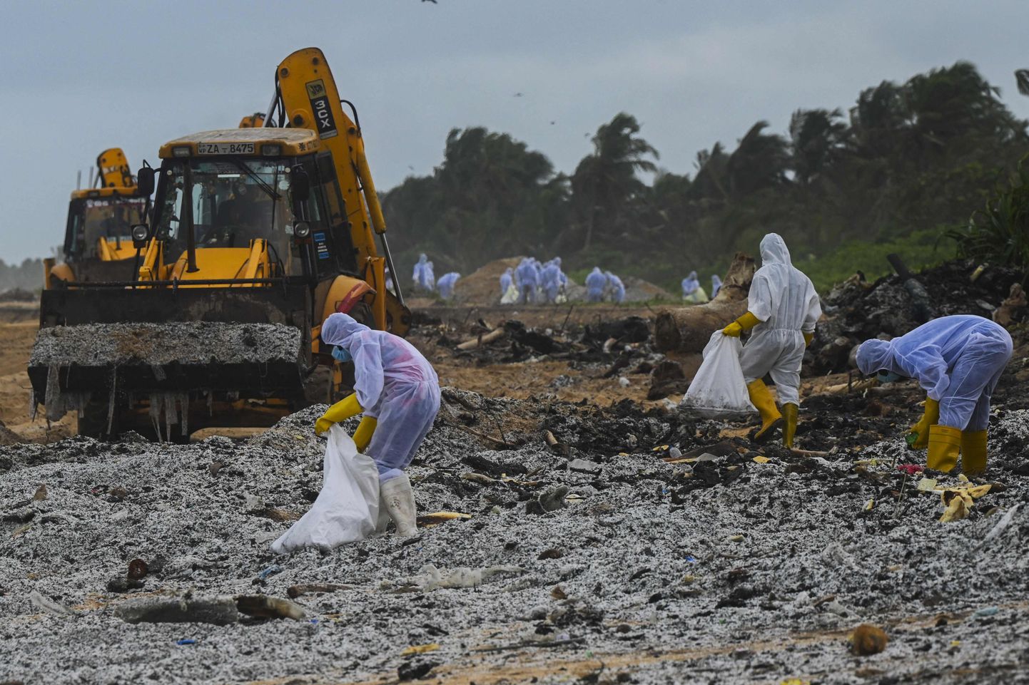 Sri Lanka sõjaväelased aitavad puhastada randa söestunud plastgraanulitest.