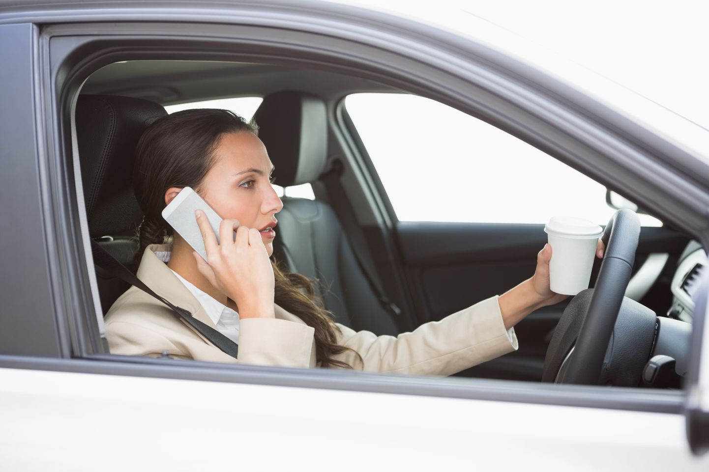 Женщина, говорящая по телефону за рулем. Иллюстративное фото.