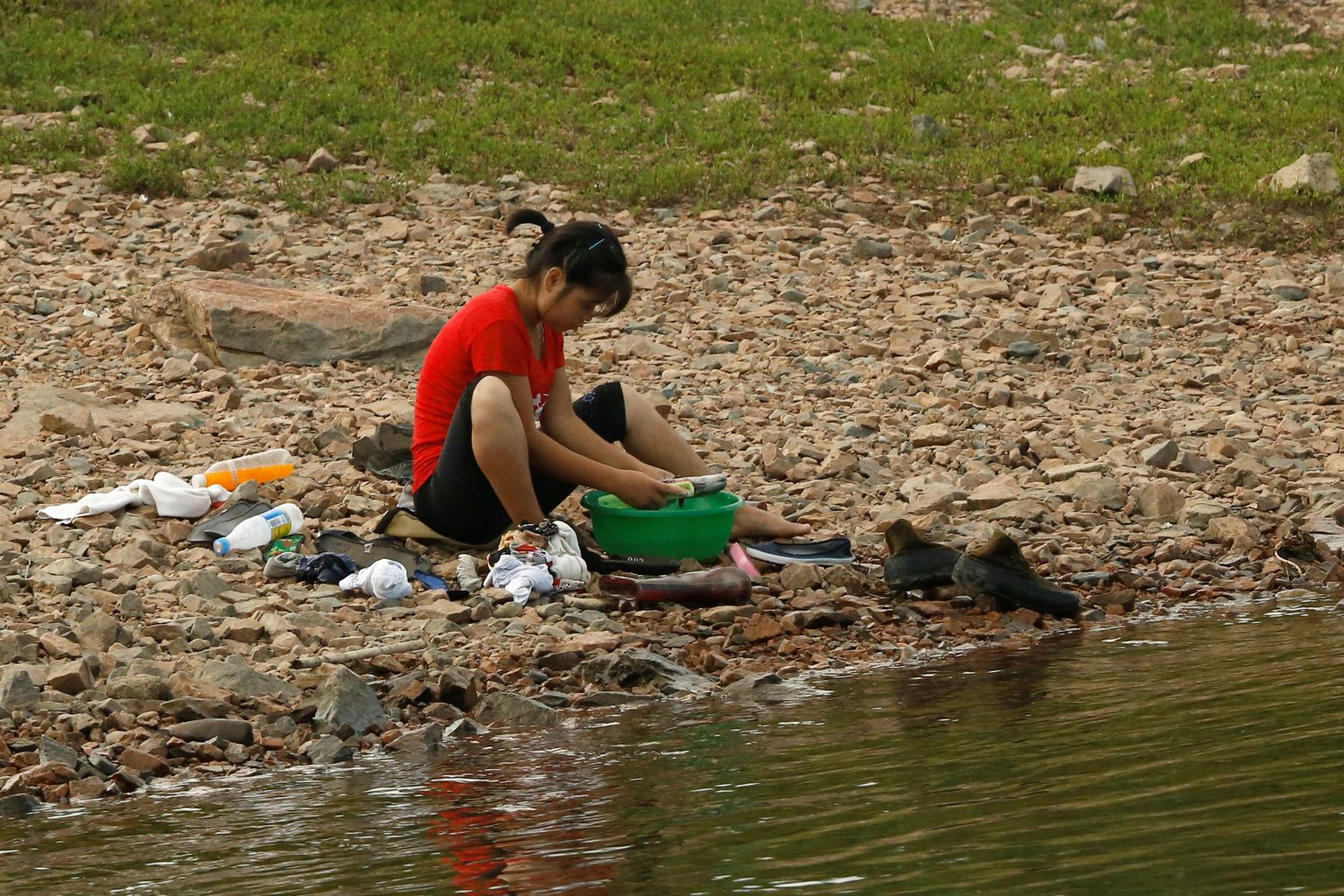 Põhja-Korea naine peseb Yalu jõe kaldal pesu. Vetevood lahutavad teda vabadusest.