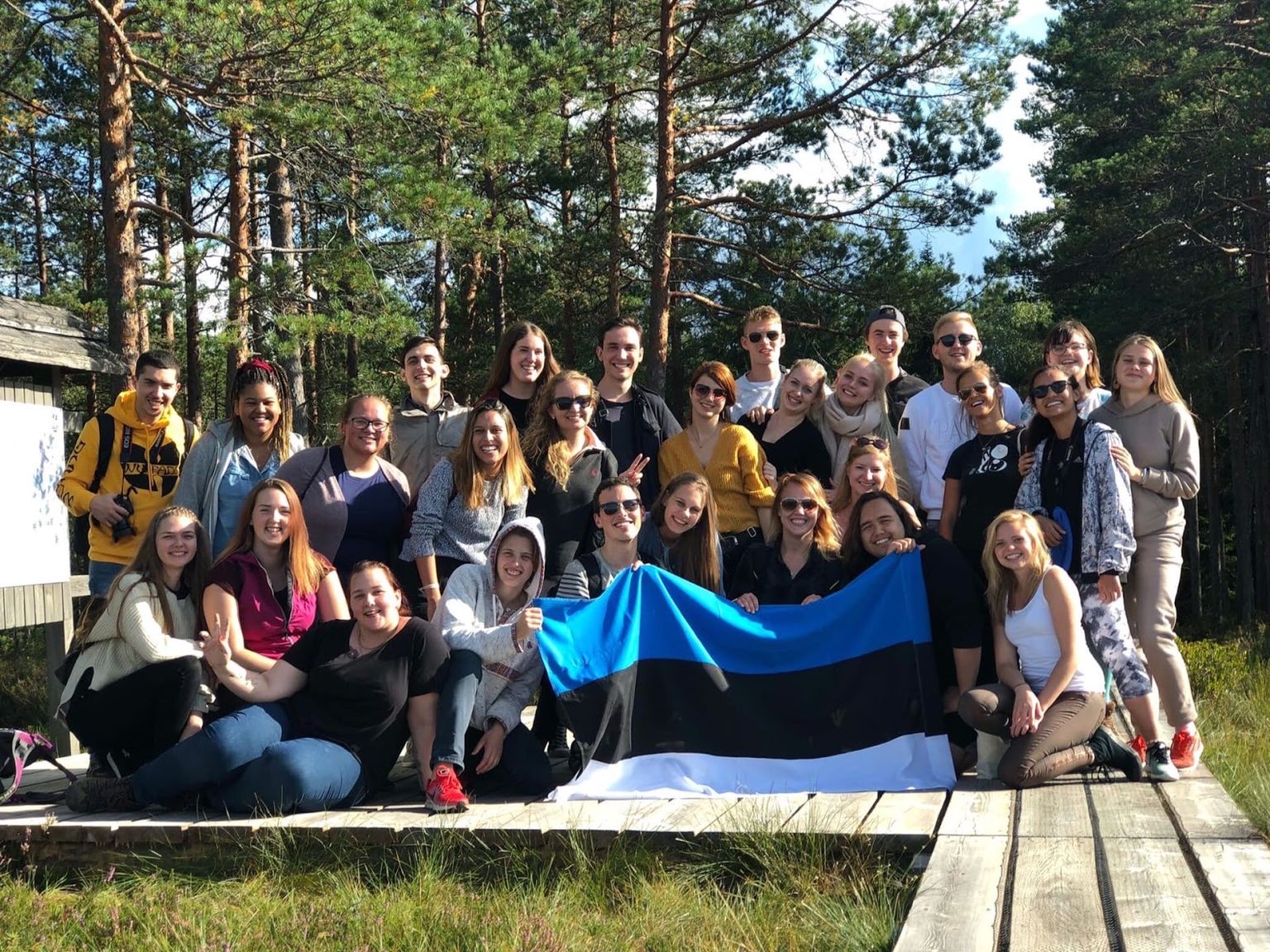 Väliseestlased poseerivad Seiklejate Vennaskonna «Tagasi juurte juurde!» üritusel Eesti lipuga.