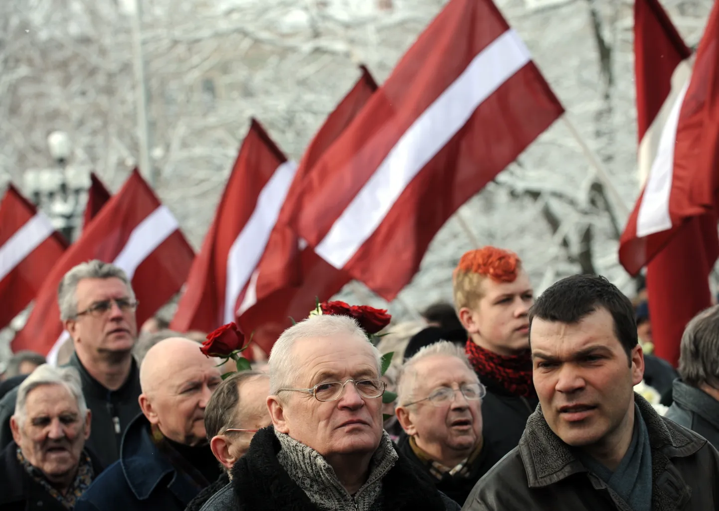 Biedrības "Daugavas vanagi Latvijā" rīkotā gājiena dalībnieki latviešu leģionāru piemiņas dienā caur jauniešu veidoto karogu aleju dodas nolikt ziedus pie Brīvības pieminekļa.