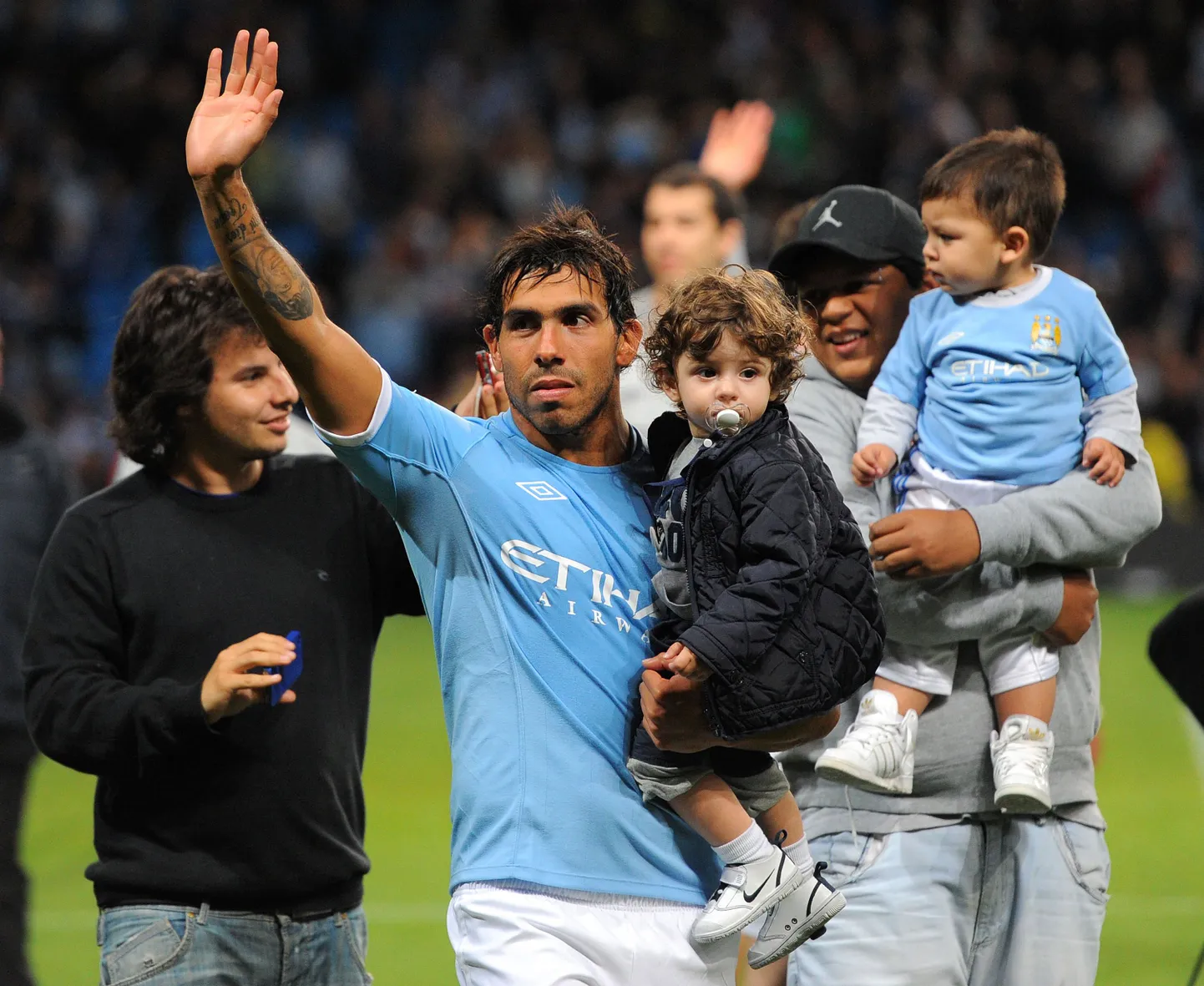 Carlos Tevez (keskel) lehvitamas Manchester City fännidele.
