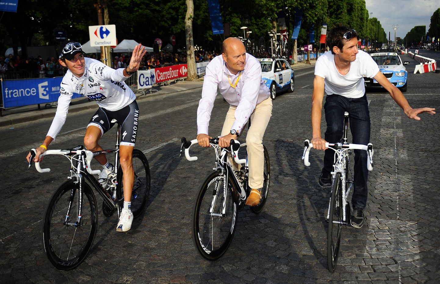 Andy Schleck (vasakul) ja tema vend Fränk (paremal) sõidavad koos Bjarne Riisiga Tour de France'i paraadil.