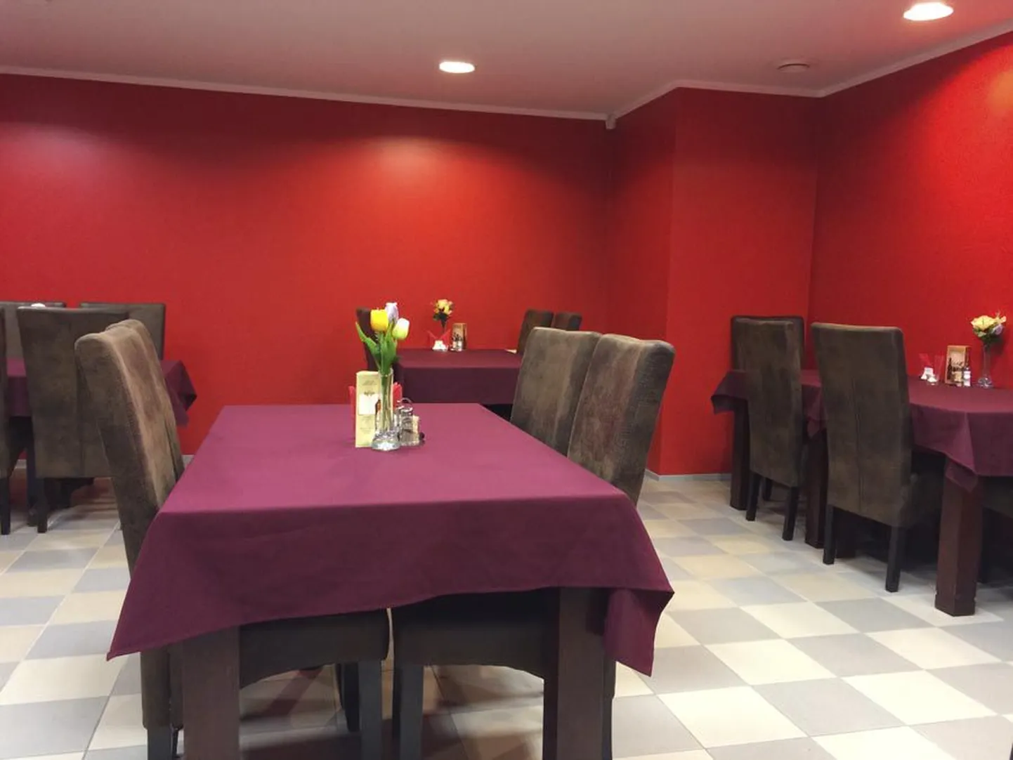 Leola ärikeskuse esimesele korrusele rajatud punastes toonides söögikoht on hubane ja mugava mööbliga.