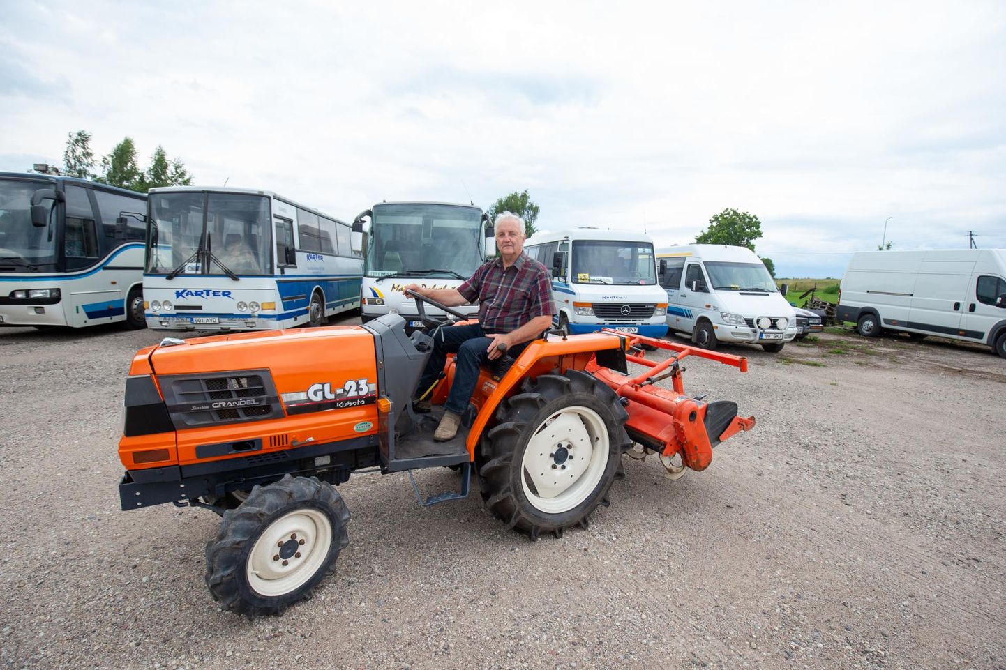 Osaühingu Karter juht Heino Tafenau poseerib koos ainsa praegu müügil oleva traktoriga. Tagaplaanil seisavad bussid, mis tellimuste puudumise tõttu pole saanud sõidus käia.