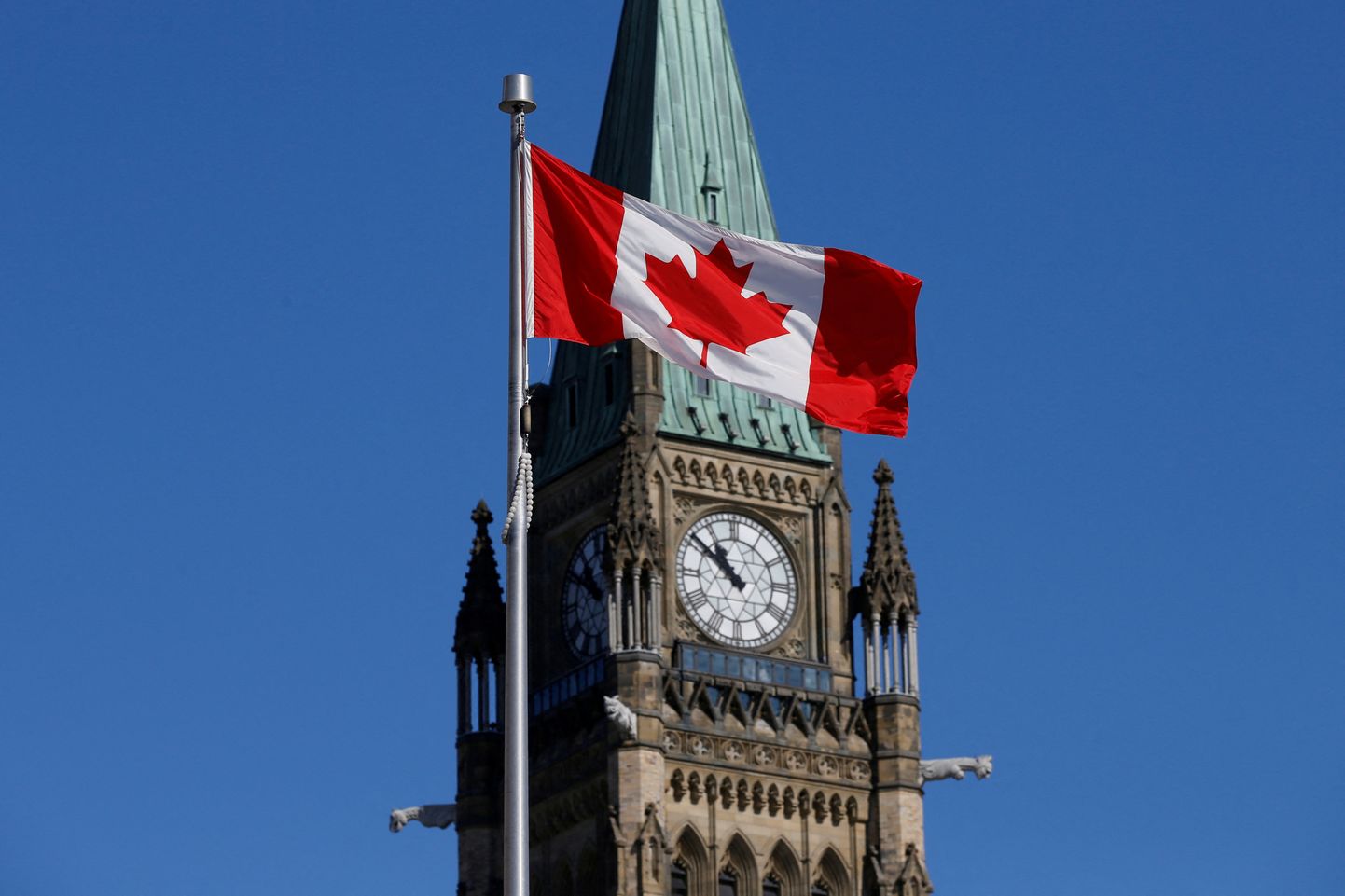 Канадский флаг развевается перед Башней мира на Парламентском холме в Оттаве.
