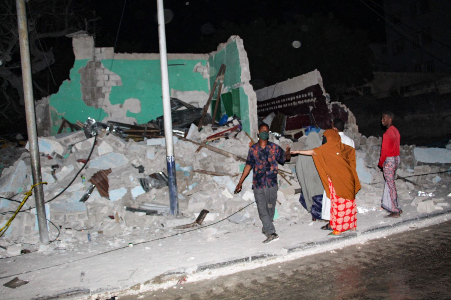 Жители возле дома, который разрушила группировка "Аш-Шабаб" в Сомали