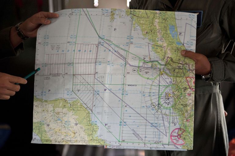 Malaisia õhujõudude esindajad vataamas lennuki otsinguala kaarti