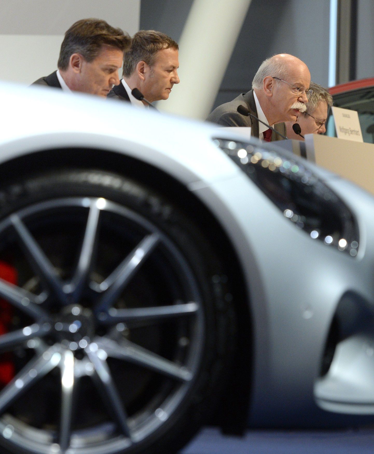 Daimler Apple'i konkurentsi ei karda, vastupidi. paremalt firma tegevjuht Dieter Zetsche, finantsjuht Bodo Uebber ning veoautode ja busside tootmise juht Wolfgang Bernhard ettevõtte aastakonverentsil, uhiuue Mercedes Benz AMG kõrval.