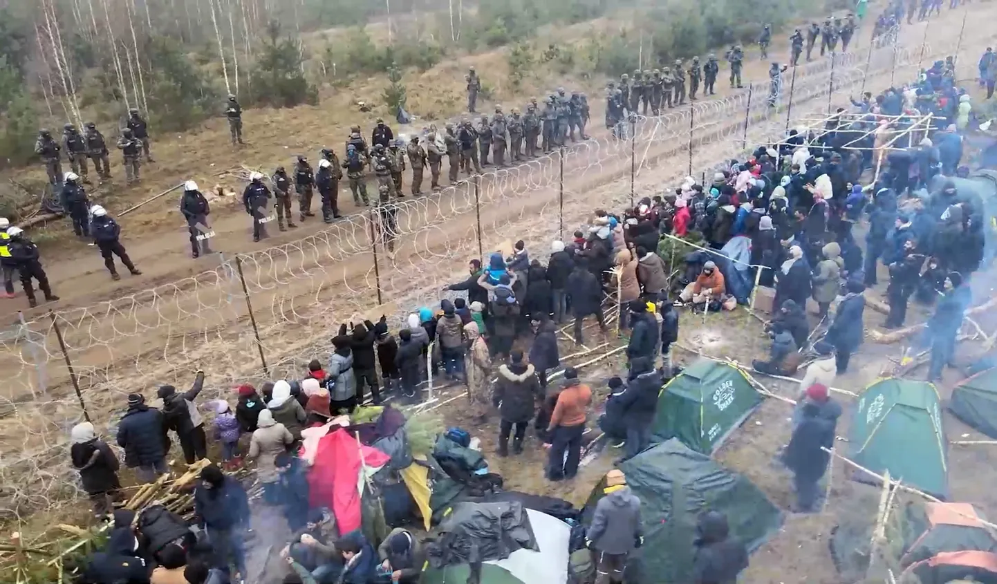 Polish servicemen and police officers guard the Belarusian-Polish border where migrants have set up a tent camp.