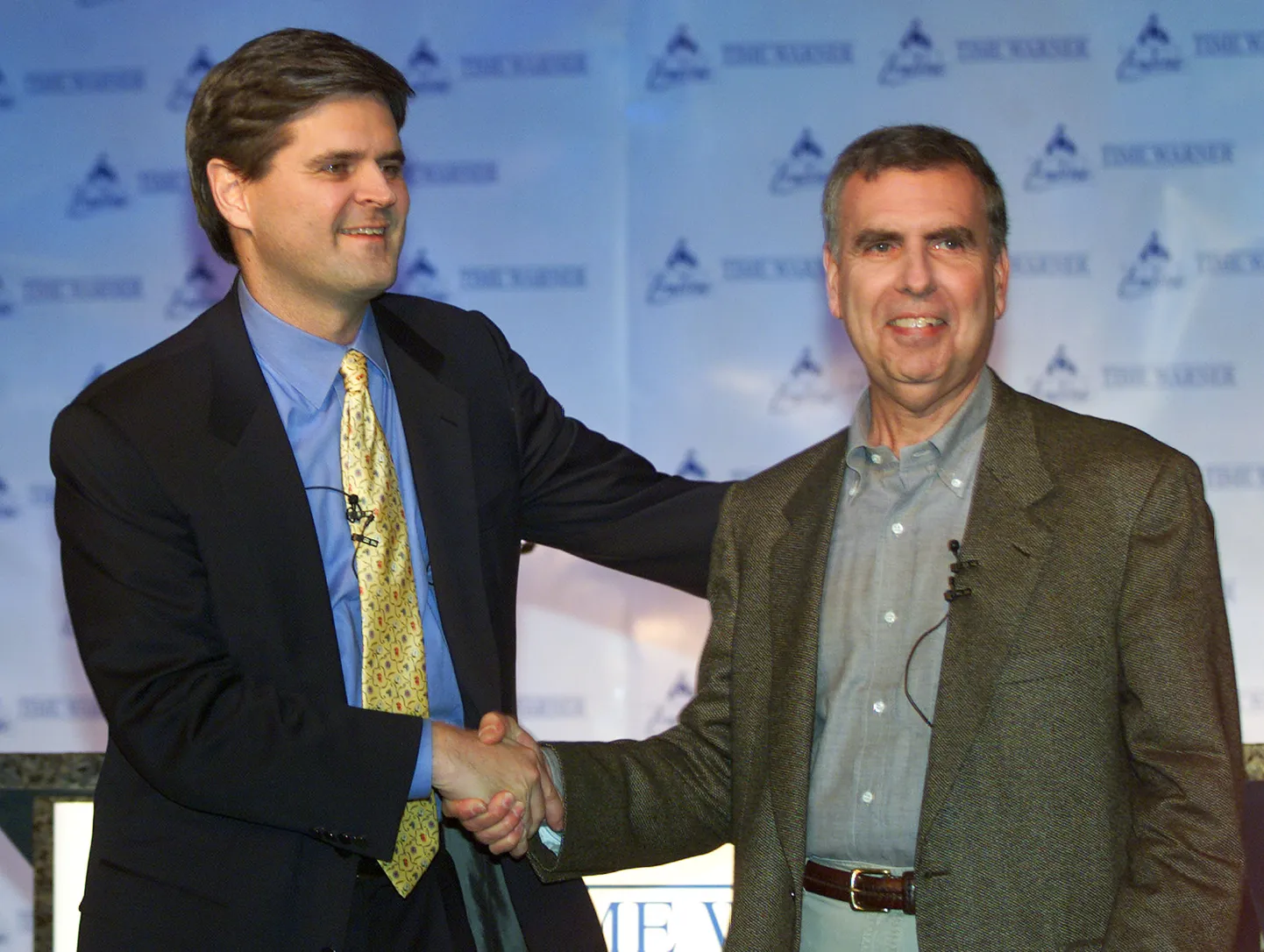 AOLi juht Steve Case surub 10. jaanuaril 2000. aasta suurtehingu puhul kätt Time Warneri juhi Gerald Leviniga. Hiigeltehing õnnestus, aga ettevõtete kombinatsioonist asja ei saanud ja 2009. aastal lõhuti ettevõtted laiali.