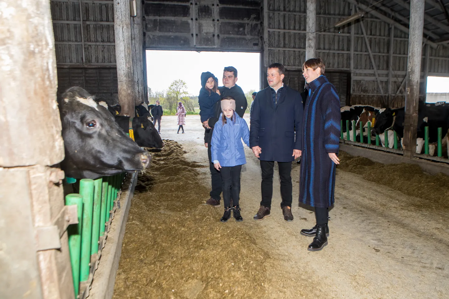 PRESIDENT PEREFARMIS: President Kersti Kaljulaid ja perefarmi juht Ülar Tänak koos tütar Janelliga. Tagaplaanil seisab Ülari poeg, ettevõtte loomakasvatusjuht Janar Tänak, kellel süles õetütar Roosi-Marie.