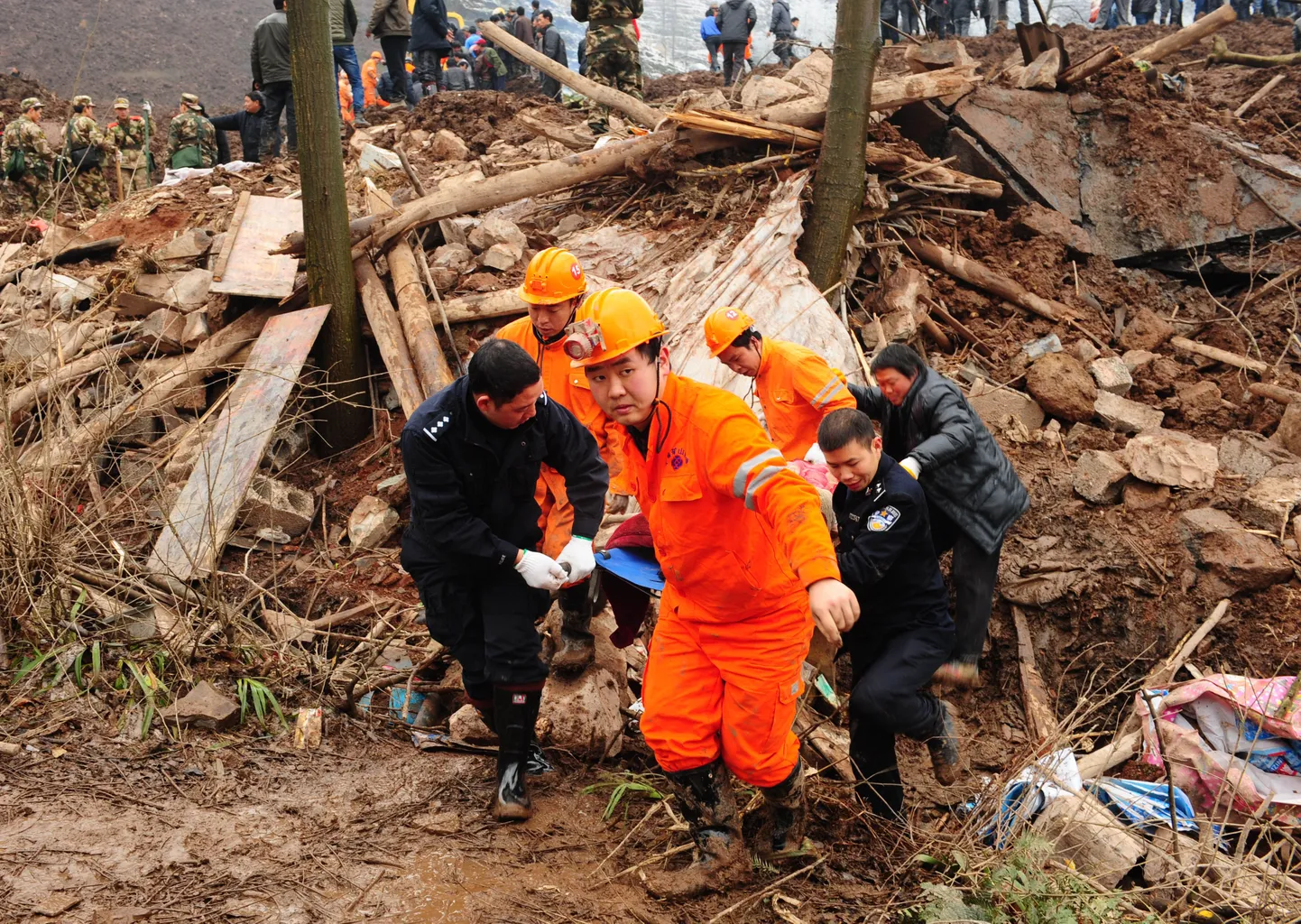 Hiina päästeteenistujad Gaopo külas  mudalaviini alla jäänud ohvri keha minema toimetamas.