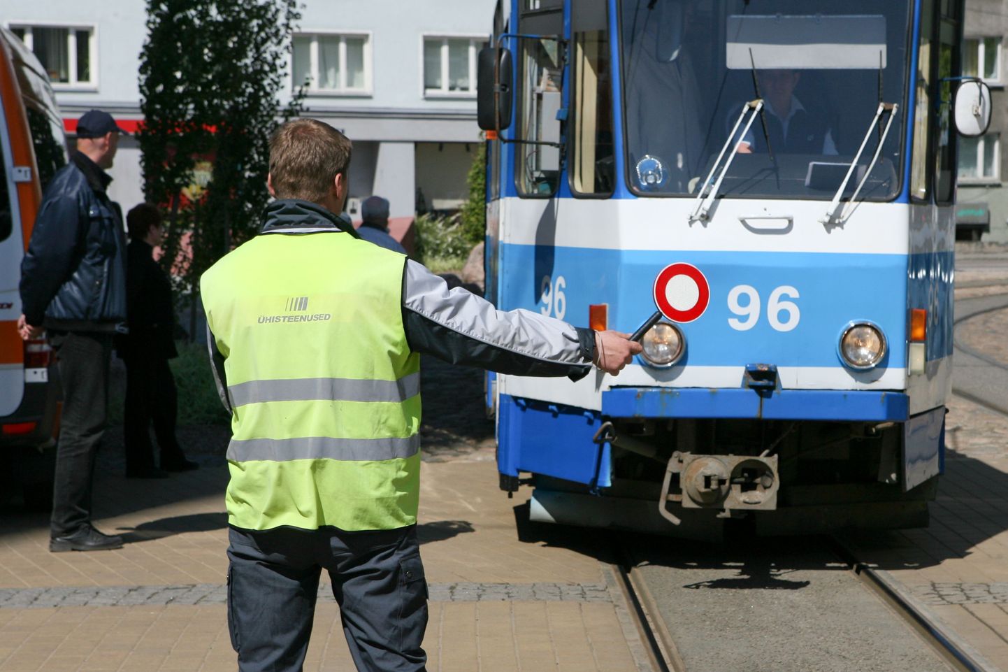 Муниципальная полиция останавливает трамвай для проверки проездных билетов.