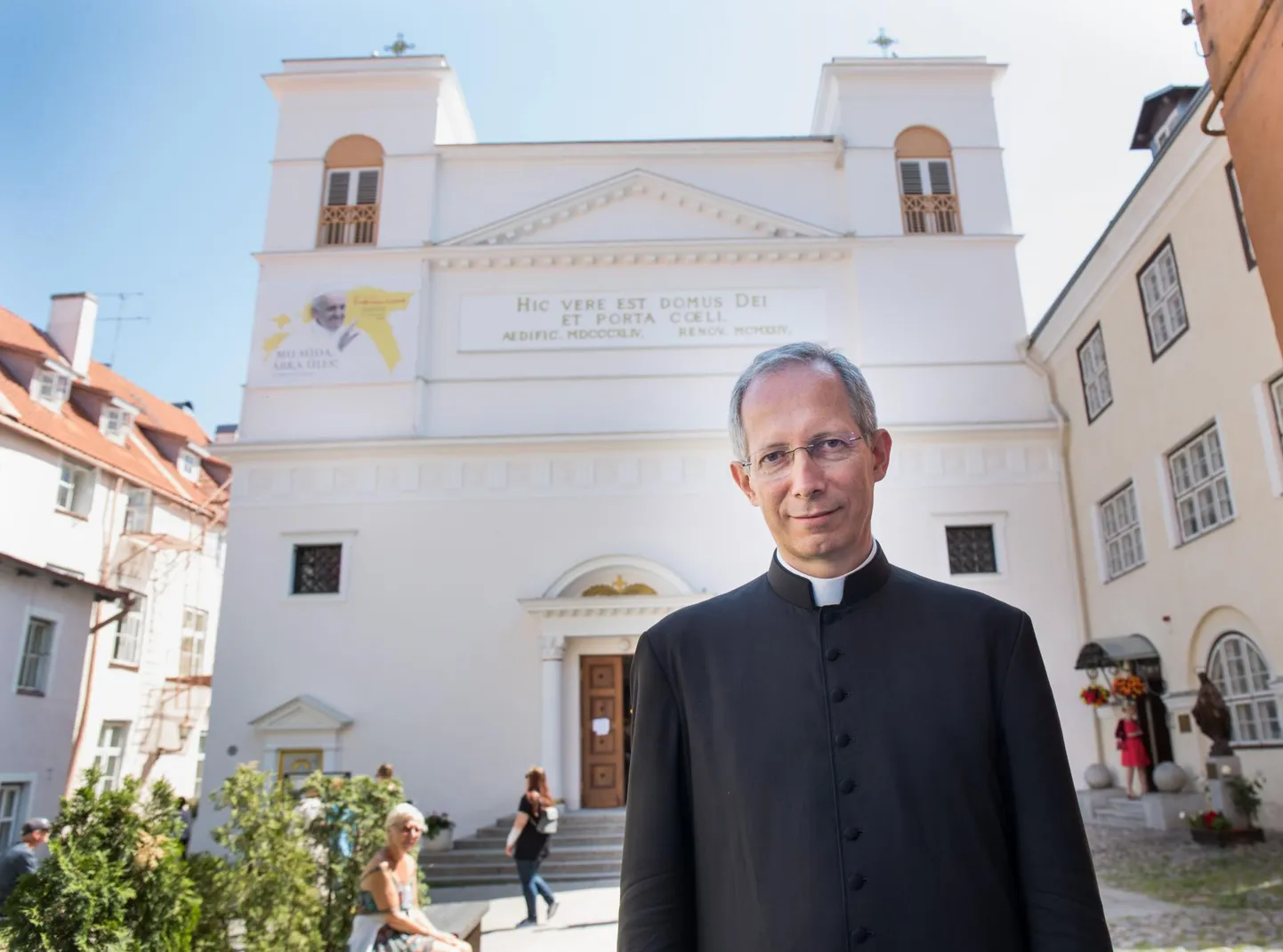 Guido Marini Tallinnas Peeter-Pauli katedraali ees, kuhu on juba riputatud tema ülemuse paavst Franciscuse tulemisest teatav plakat.