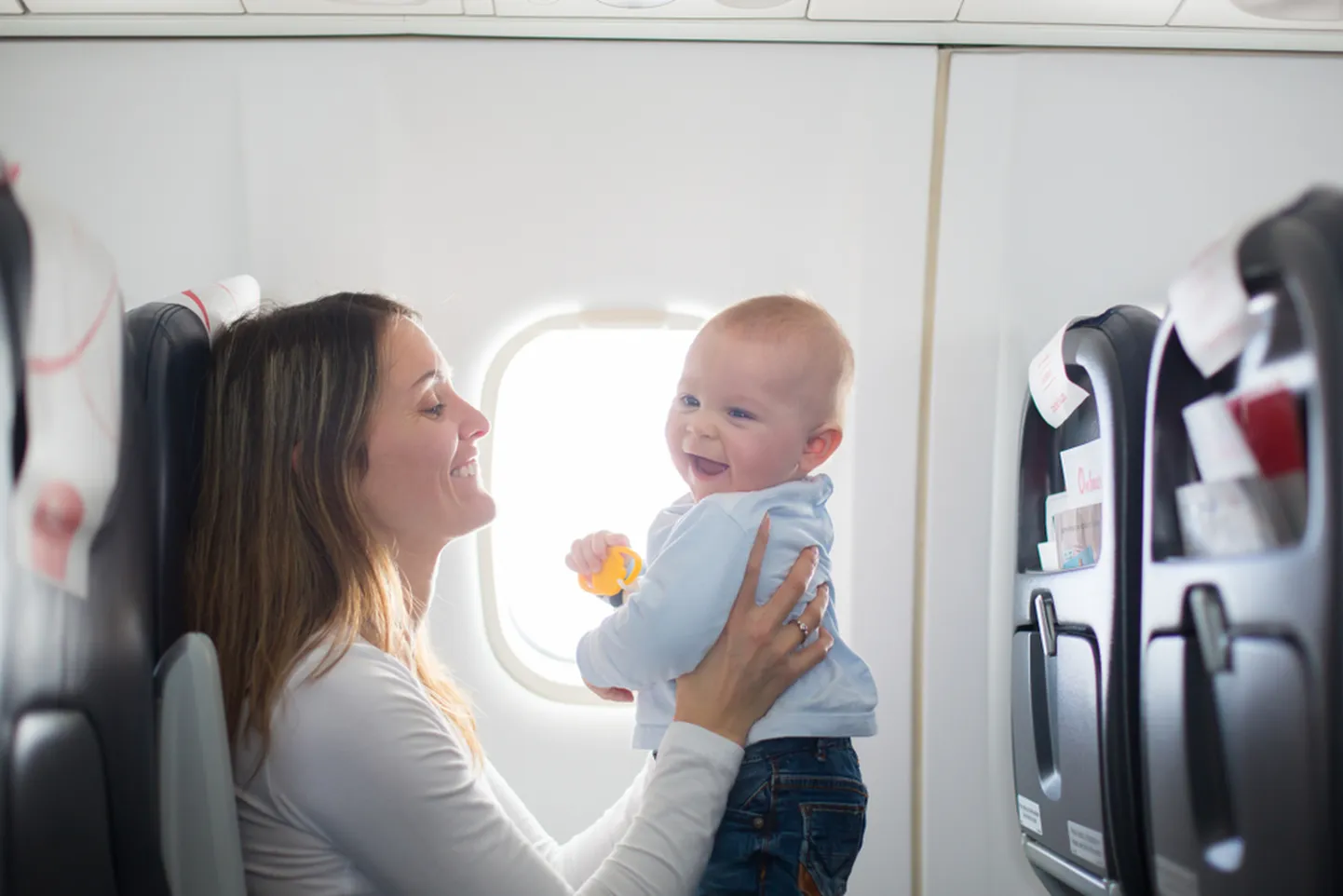 Мать с ребенком в самолете. Изображение носит иллюстративный характер.