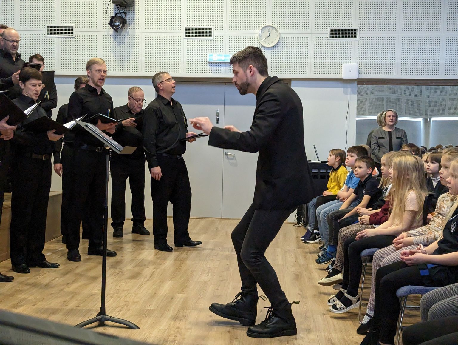 Rahvusmeeskoori laulja Kuldar Schüts dirigeerib koolikontserdil.
