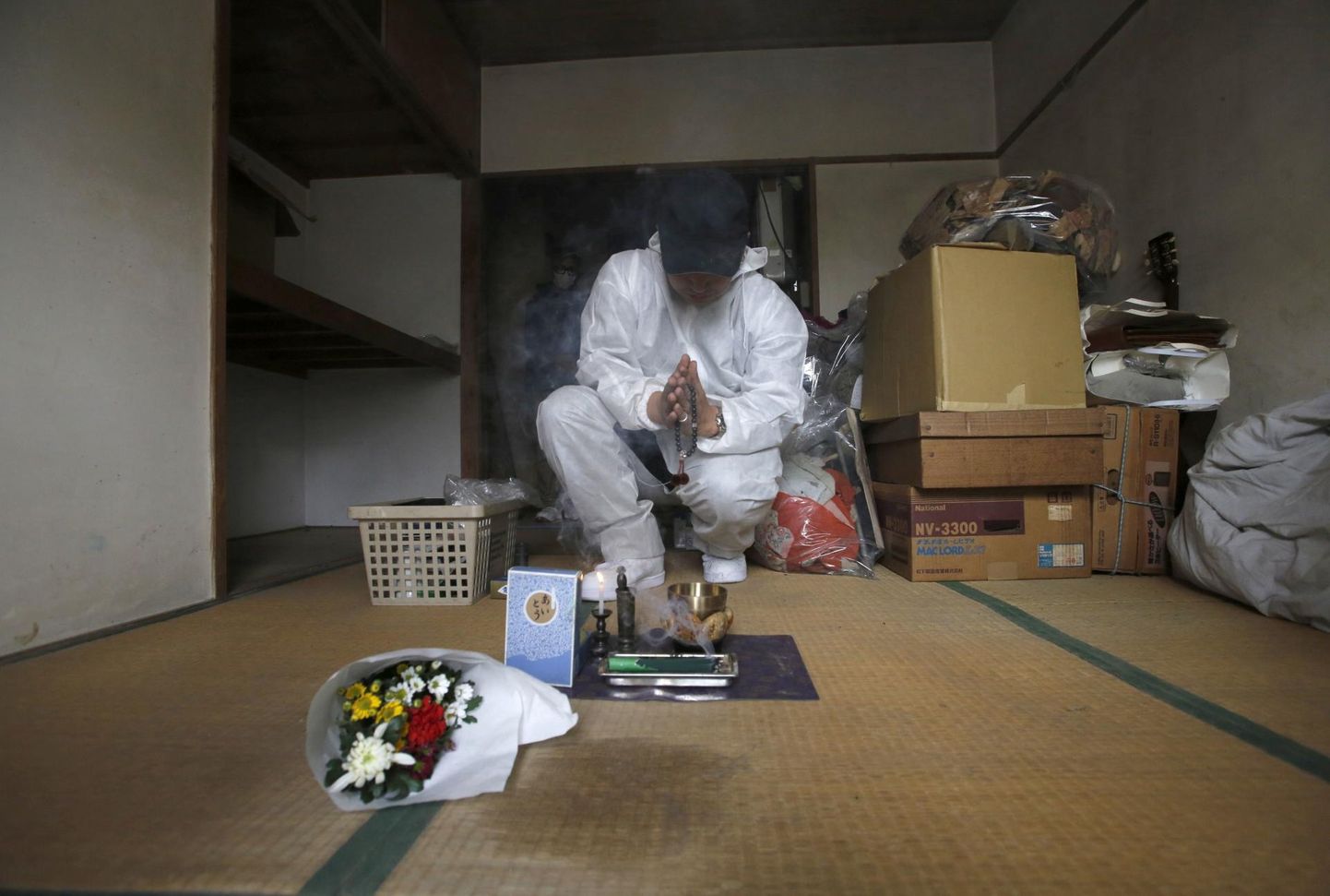 Puhastustöötaja palvetamas ühe Tokyos 85-aastaselt üksi surnud ja üle kuu aja hiljem avastatud mehe korteris pärast koristustöid. Jaapanis elab üksi umbes viis miljonit vanainimest ja üksindussurmade arv on kasvamas.