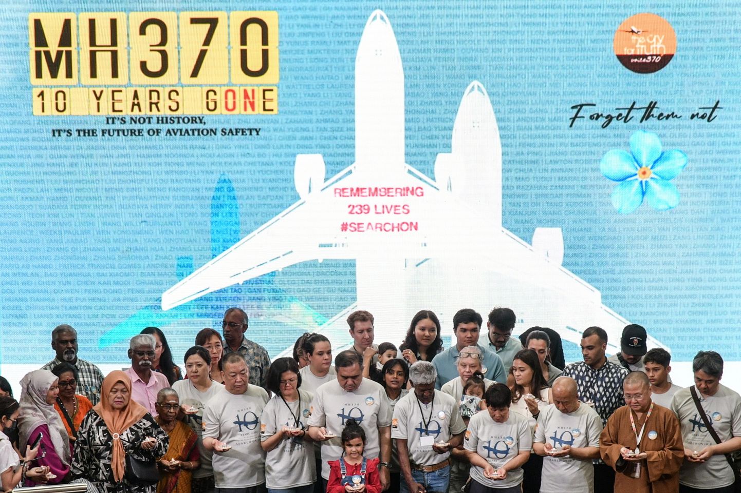 Kadunud Malaysian Airlinesi lennu MH370 pardal olnud reisijate ja meeskonna pereliikmed ja Malaisia transpordiminister Anthony Loke (ees) seisavad üheskoos grupipildi tegemiseks mälestusüritusel, millega tähistatakse lennuki kadumise 10. aastapäeva.