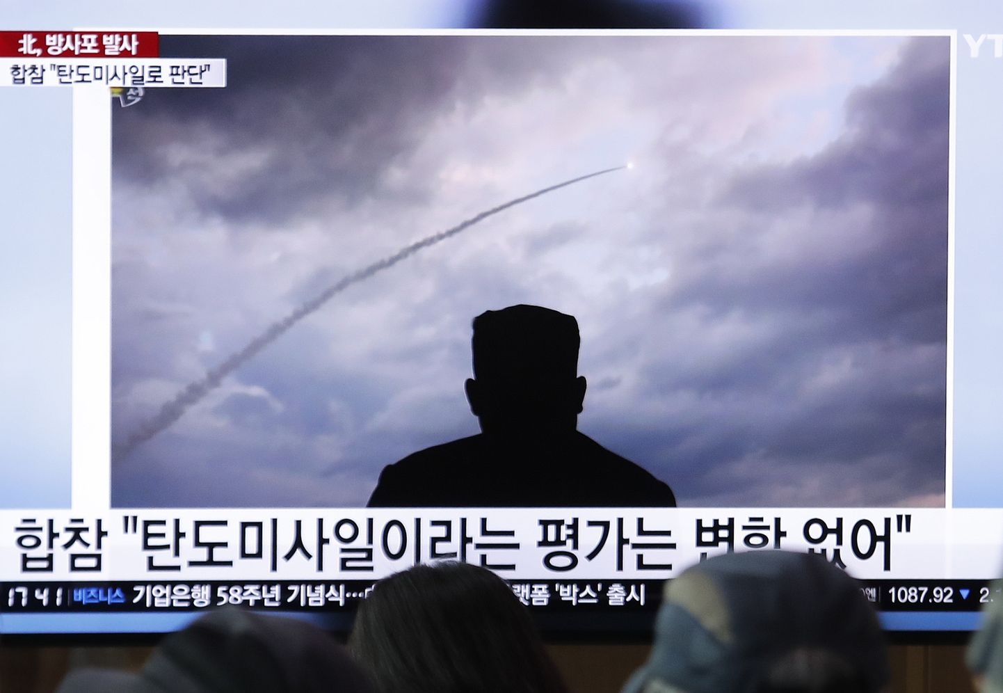 Inimesed vaatamas telekast Põhja-Korea raketikatsetust. Raketikaare all seljaga vaataja poole olev mees on Põhja-Korea liider Kim Jong-un.