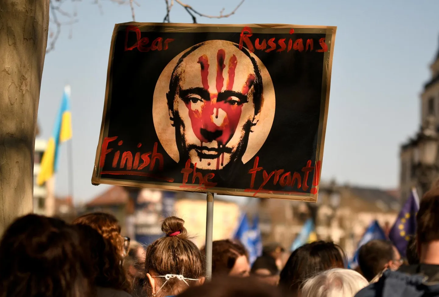 Möödunud pühapäeval Saksamaal Frankfurdis Venemaa agressiooni vastasel meeleavaldusel käigus olnud plakatil on Vladimir Putini pilt ja ingliskeelne kiri: «Kallid venelased, tehke türannile ots peale!»