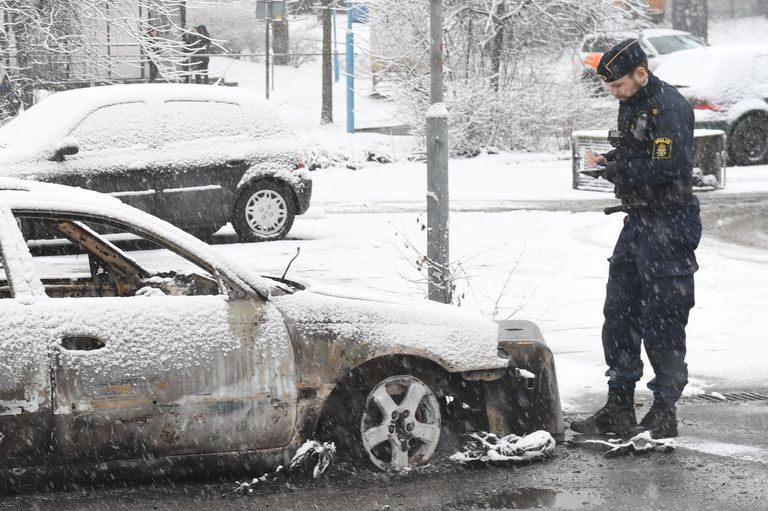 Rootsi politseinik uurimas mässu ajal põletatud autosid