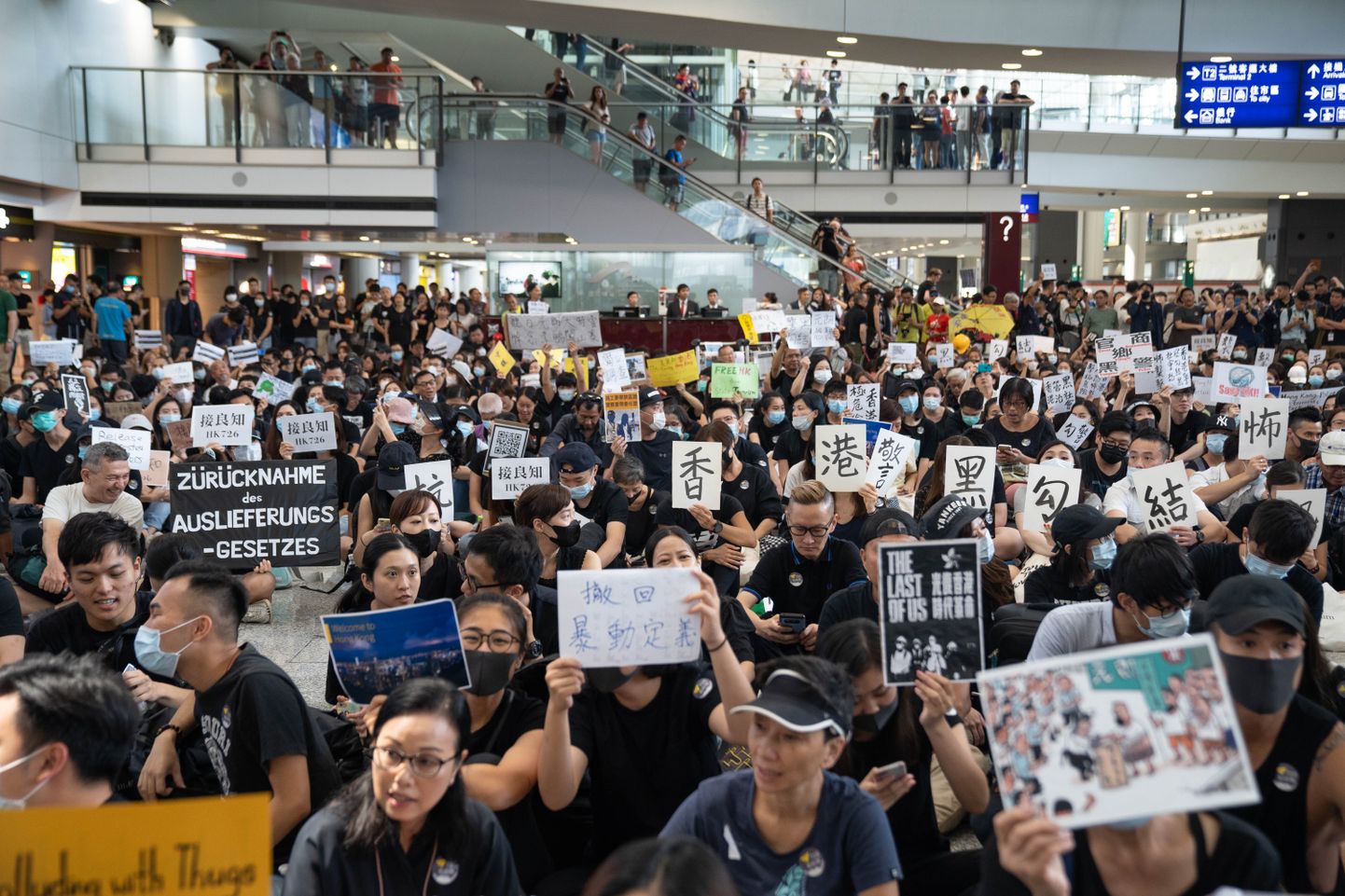 Protestijad Hongkongi lennujaama saabuvate lendude saalis meelt avaldamas, et "harida" külalisi demonstratsioonide asjus.