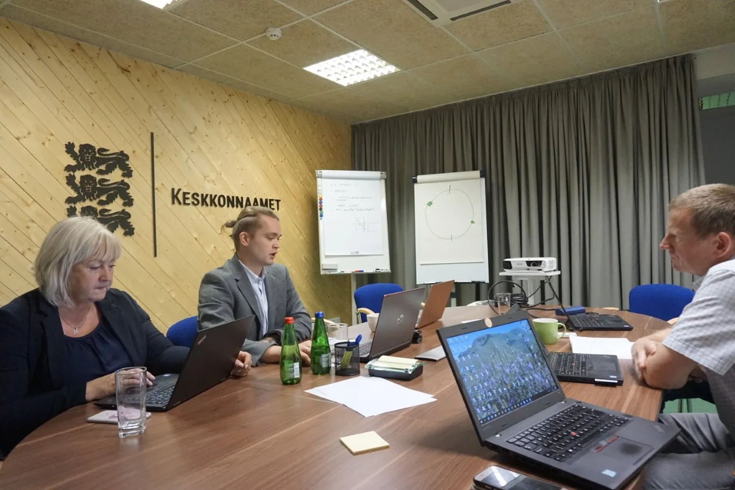 Eesti Metsa Abiks metsloomade kaitse koordinaator Maarika Kuhlberg ja jurist Sven Anton keskkonnaameti looduskaitseosakonna juhi Tarvo Roosega nõu pidamas.