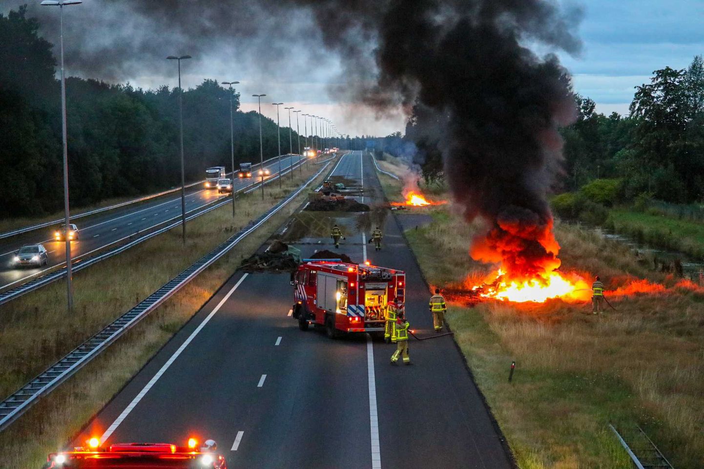 Tuletõrjujad sündmuskohal, kus põllumehed süütasid Apeldoornis A50 maantee ääres toimunud protesti ajal sõnniku ja heinapallid.