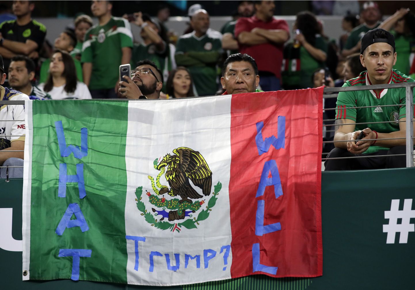 Mehhiko jalgpallifännid lipuga, millel kiri «Mis müür, Trump?».