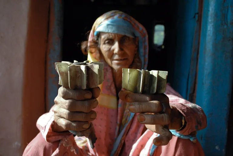 Pakistani naine näitab oma kodu juurest leitut.