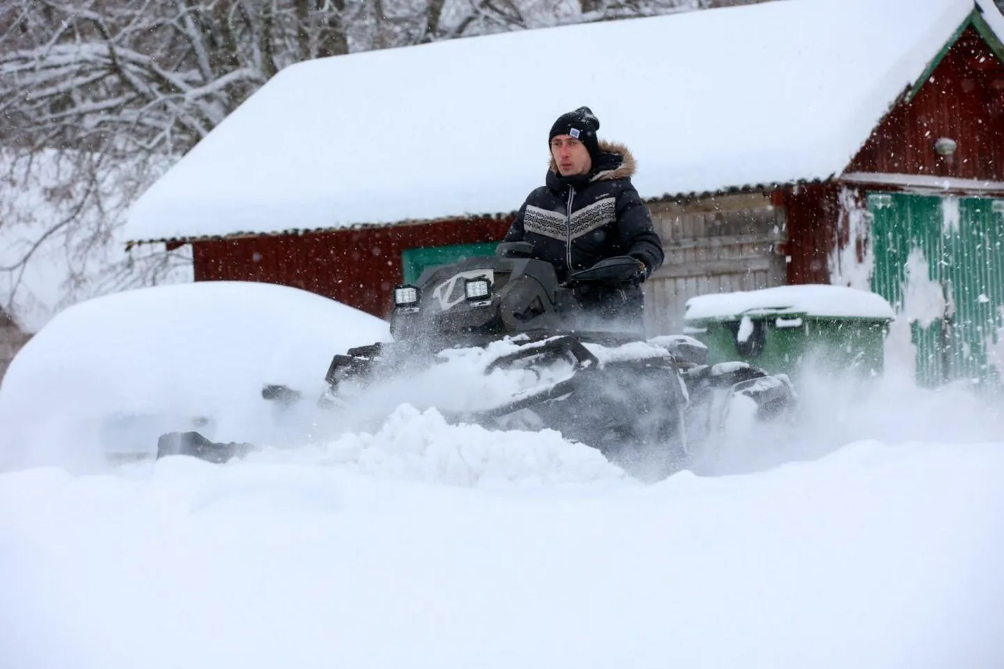 Roger Jalak lükkab oma ATV-ga lund ka naabrite hoovidest.