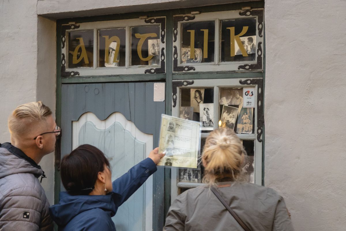 Антикварный магазин на улице Дункри, в руках у участников Секскурсии фотографии известных проституток XX века в Эстонии 